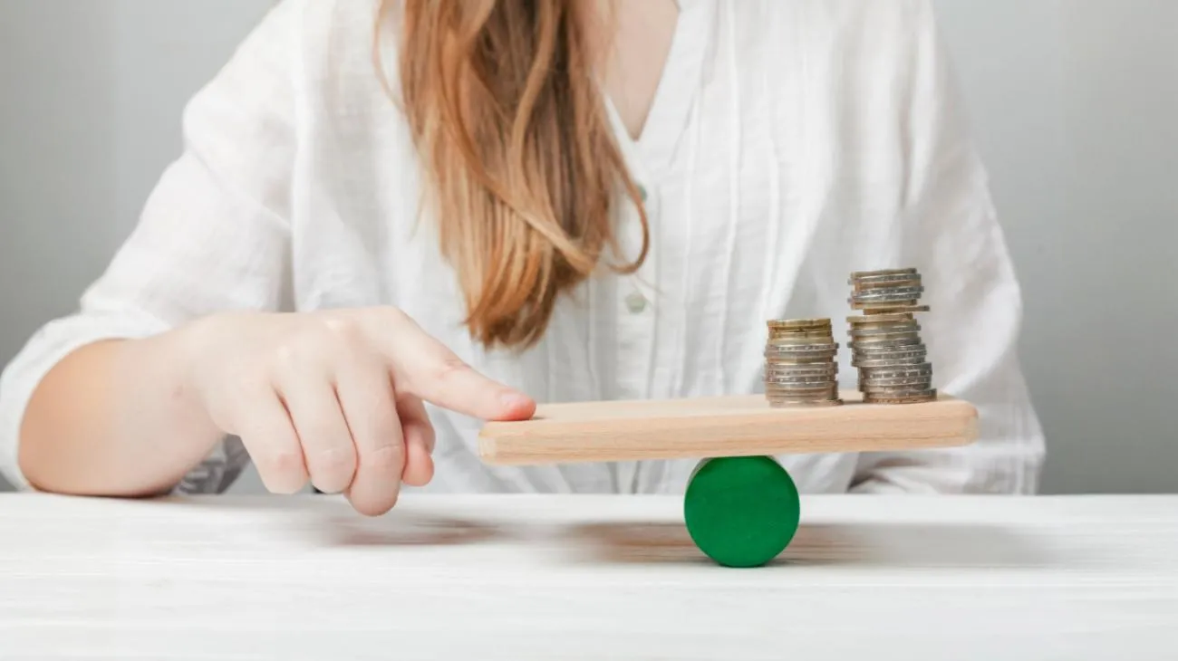 Woman balancing coins on scale